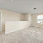 A bright, empty room with beige walls and carpet, ready for interior design ideas.