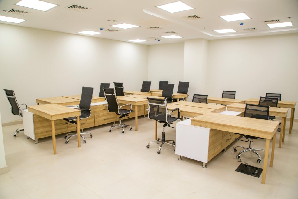 Spacious modern office with wooden desks and ergonomic chairs, ideal for team workspace.