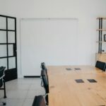 A clean and modern office space with wooden tables, chairs, and shelves, ideal for a creative work environment.